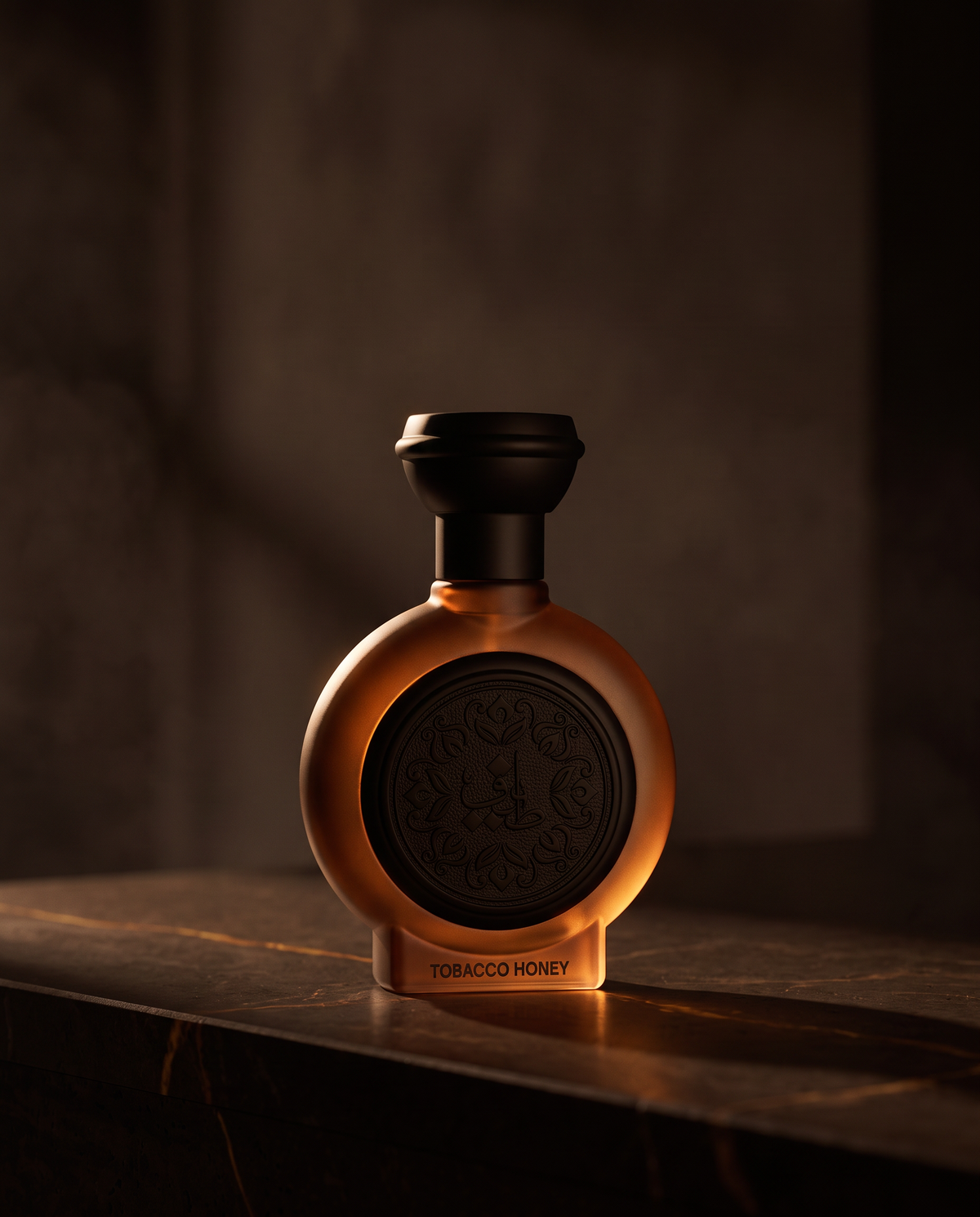 TOBACCO HONEY by Taif Al Emarat bottle on dark stone in warm amber light